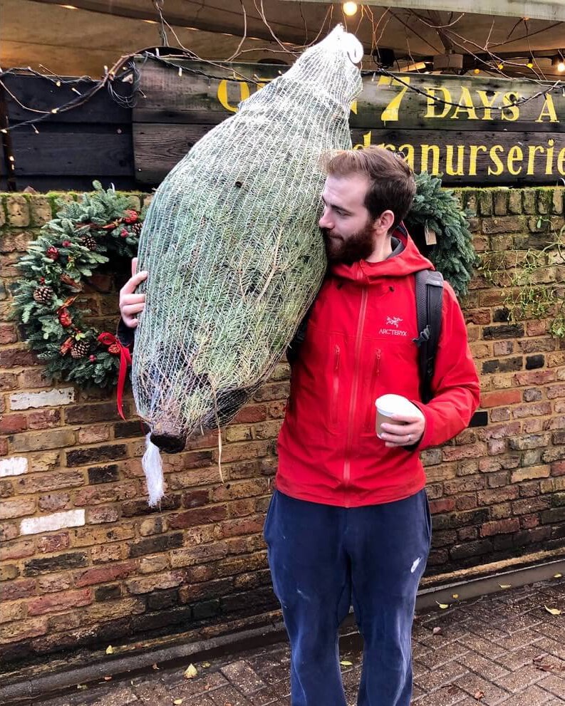 A photo of me outside the local nurseries with a wrapped Christmas tree