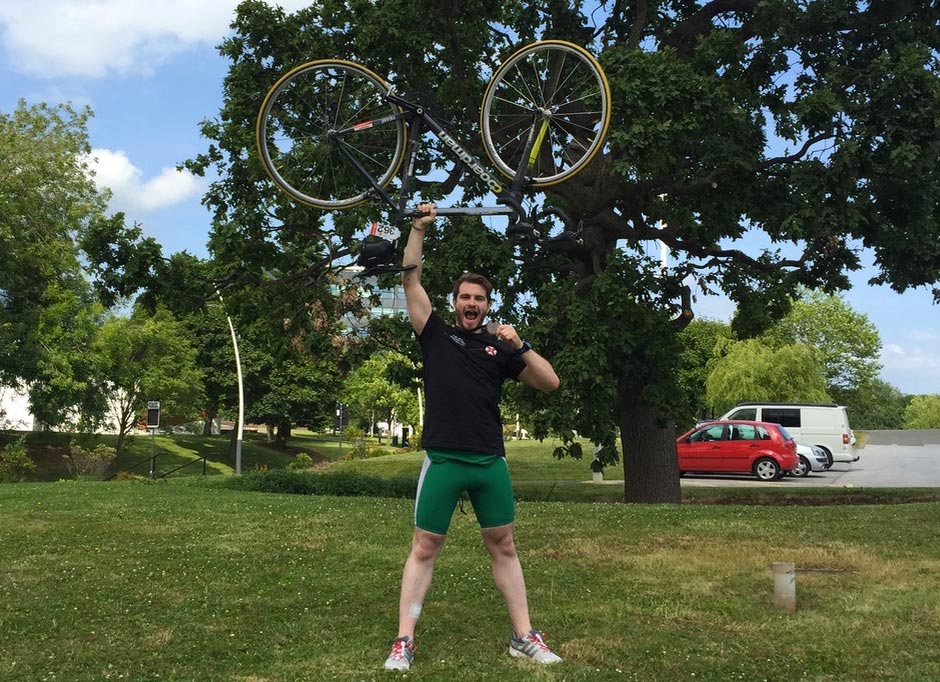 A photo of me with my bike above my head, and my medal in my hand!